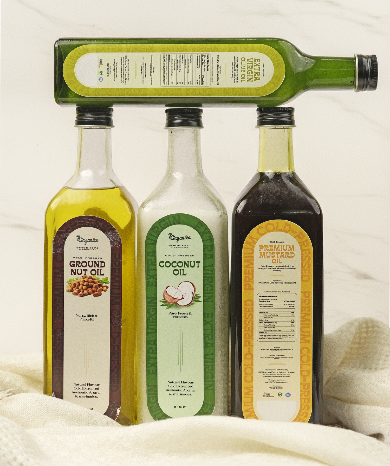 Three bottles of different oils with labels on a white background